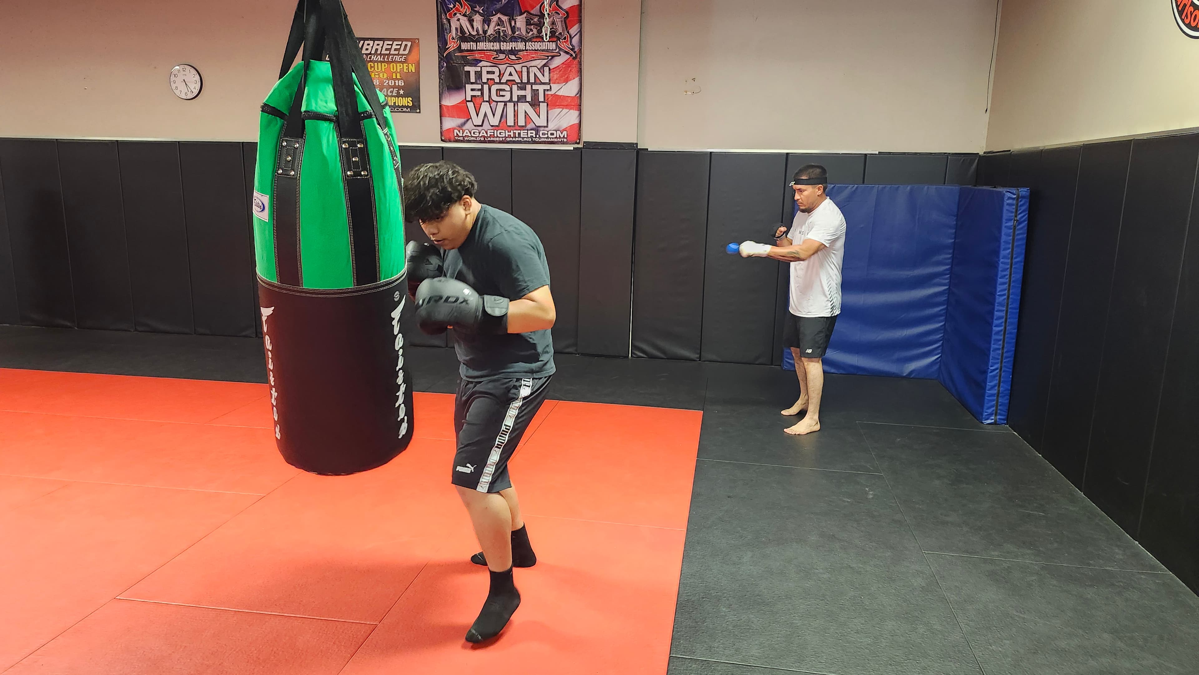 A Barrick BJJ student working punches on a heavy bag