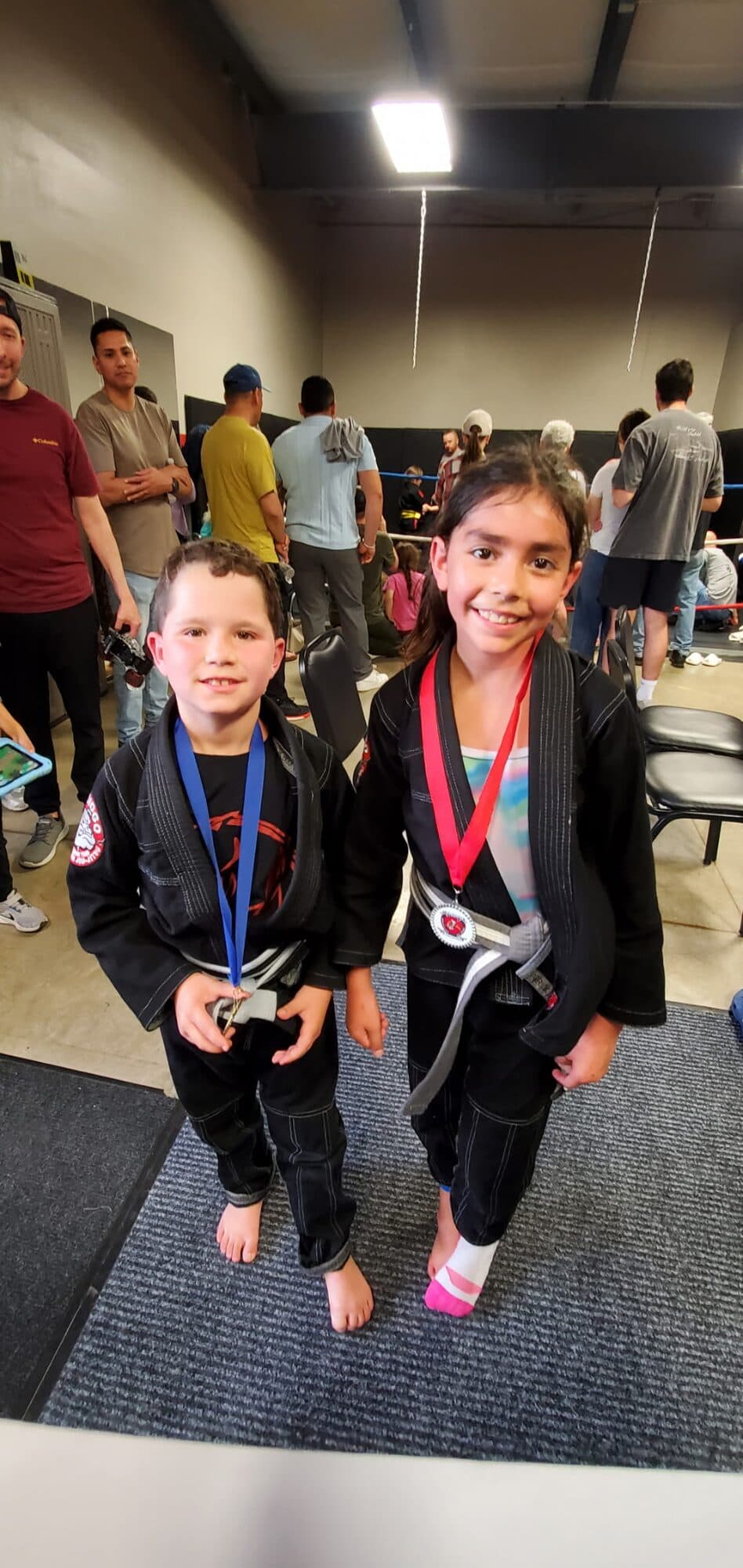 Two young Barrick BJJ students with their medals after a Brazilian Jiu-Jitsu tournament