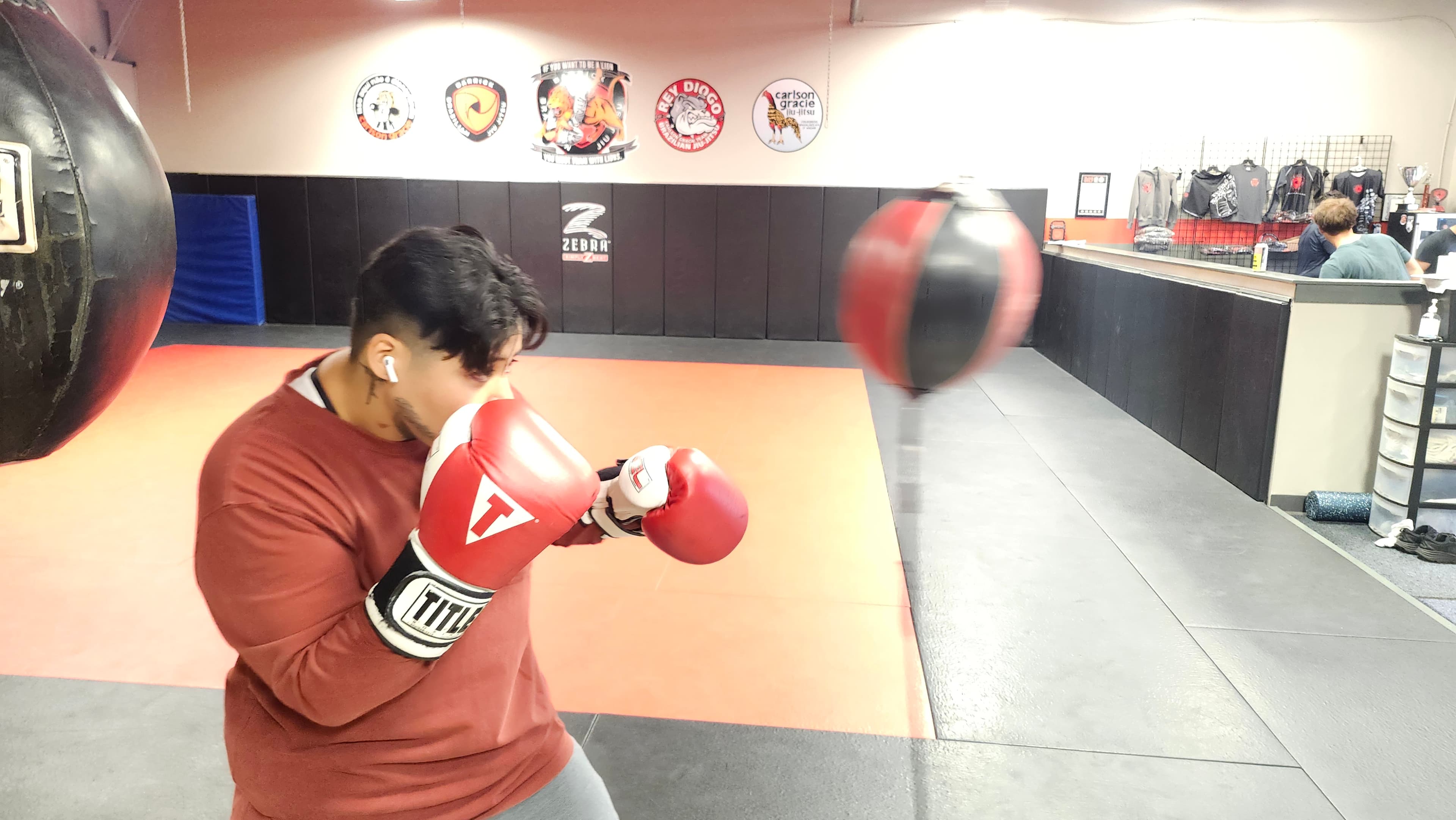 A young Barrick BJJ boxing student practicing punches with gloves