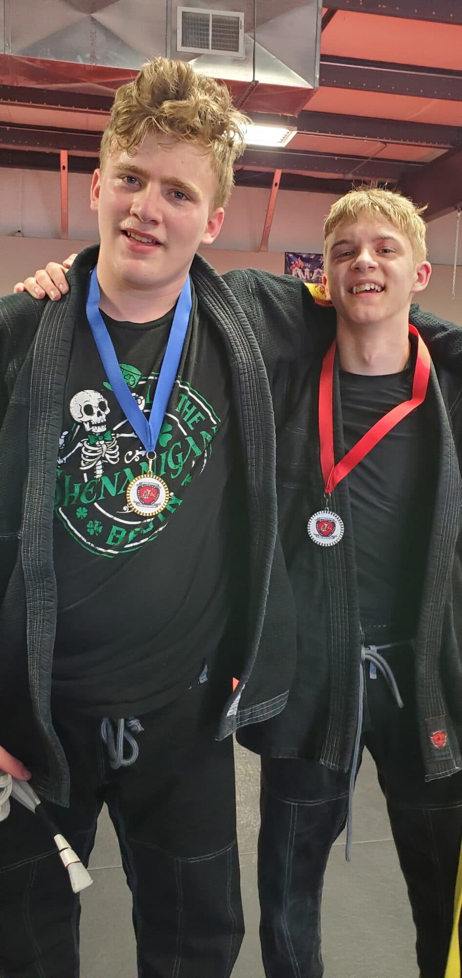 Two teenage Barrick BJJ teammates with medals after competing in a jiu-jitsu tournament
